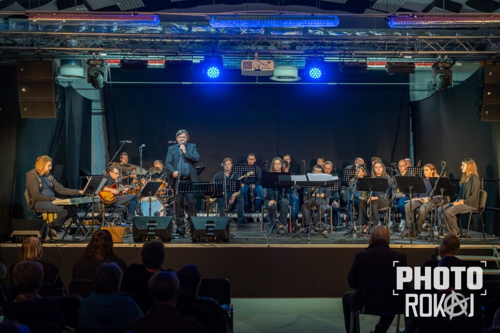 Gradska glazba Samobor i Igor Geržina tijekom edukacijskog koncerta za mlade u Samoboru, dirigent Robert Polgar, publika uživa u glazbi.