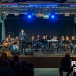 Gradska glazba Samobor i Igor Geržina tijekom edukacijskog koncerta za mlade u Samoboru, dirigent Robert Polgar, publika uživa u glazbi.